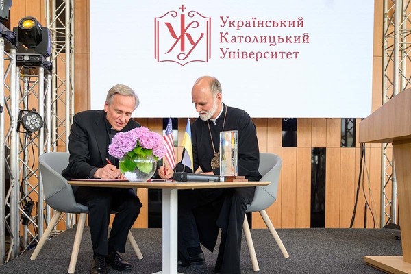 Notre Dame President Rev. John I. Jenkins, C.S.C. signs the memorandum of understanding with Ukrainian Catholic Archbishop Borys Gudziak at the Ukrainian Catholic University in 2019.